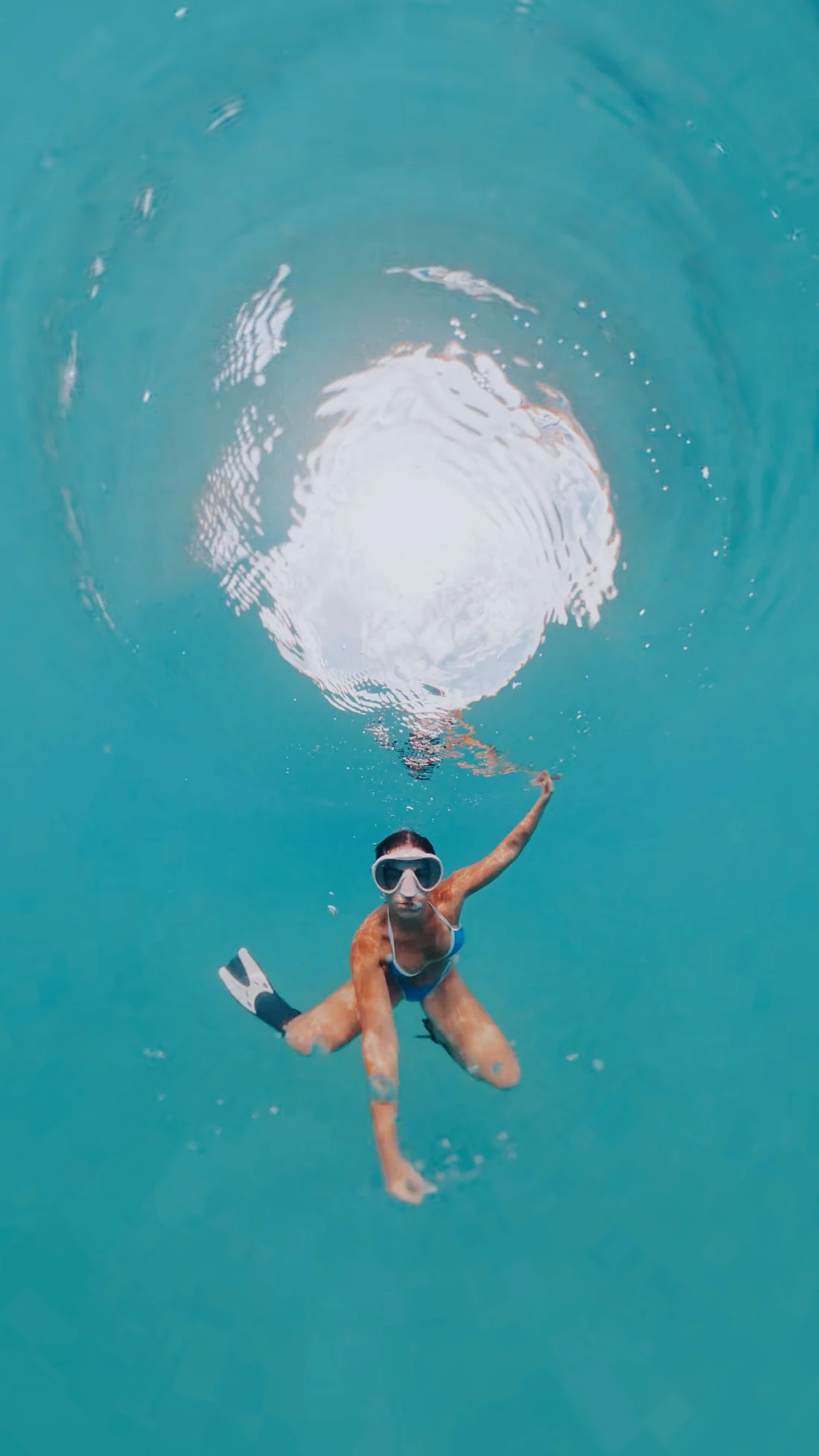 Snorkeler in turquoise water from above